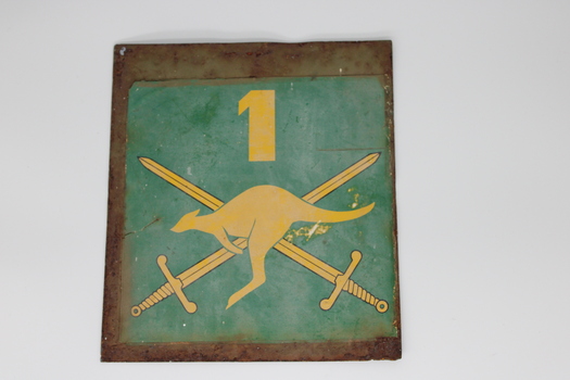 Green metal sign with yellow image of kangaroo and 2 swords crossed behind and the number 1 above.