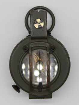 A khaki coloured metal compass.