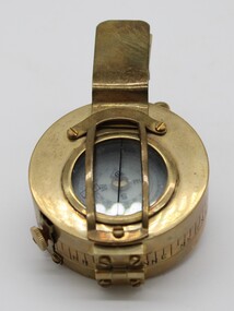 A brass compass with opening lid which is considered to be standard army issue.