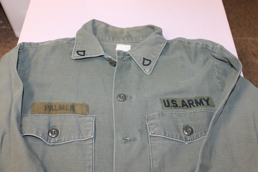 United States army green long sleeve shirt with metal rank badges on collar the name of "Palmer" on right hand top pocket.