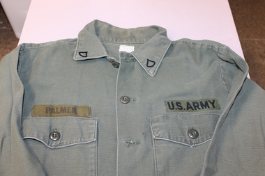 United States army green long sleeve shirt with metal rank badges on collar the name of "Palmer" on right hand top pocket.