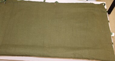 Khaki army issue woollen blanket with press studs and tabs to join the blanket it half.