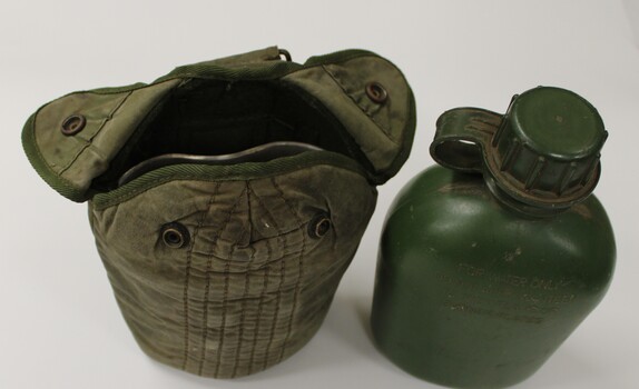 A drinking water bottle with canvas pouch.