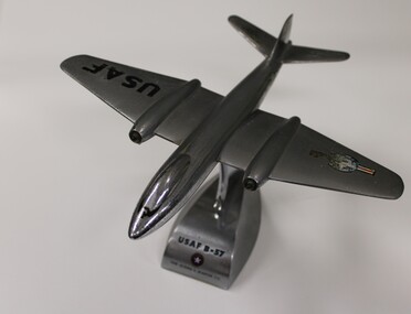 A solid metal model of a USAF B57 on a metal stand.