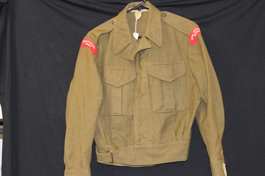 An wool army issue battle jacket with red patches on either sleeve,