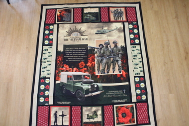 A large handmade quilt with panels of various designs depicting the Vietnam conflict.