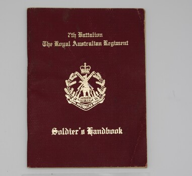 Maroon coloured booklet with gold lettering. 