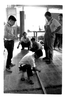 Six (6) men rebuilding X-ray building. 