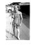 Black and white photo of a man on crutches with plaster on right arm and left leg. An ex white mouse now a prisoner.