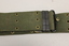 Khaki webbed belt with brass buckle, metal clamps and brass eyelets.