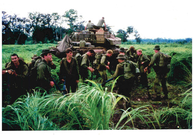 Coloured image of a jungle scene of soldiers fully equipment for combat.