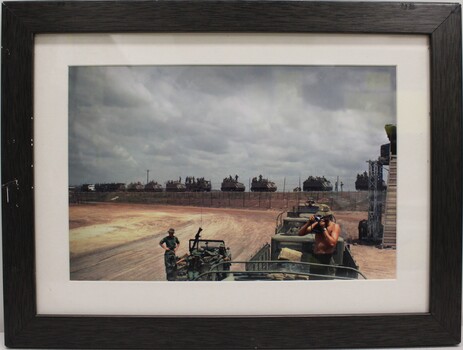 A photograph of military vehicles in convoy on high ground