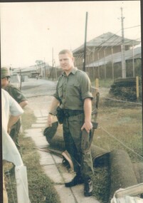 Photograph of solider, Lette, Allen Doran holding his hat and riffle.