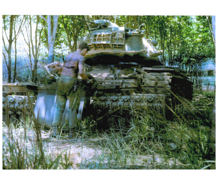 Soldier checking mine clearing tank for damage.