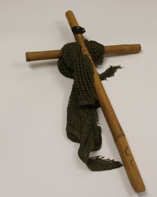 Bamboo cross with an army issue sweat rag draped around and a metal name plate attached. 