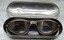 Small metal case containing aviators goggles and small booklet.