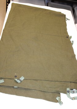 Woollen blanket with cotton ties and press studs.