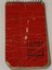 Small metal spiral bound booklet with red cover.