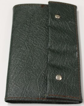Green folder with studs to fasten qualification certificates for flight.