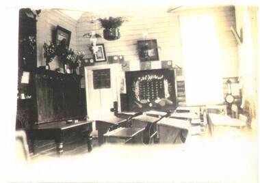 Sepia photo of interior of Scotsburn School, c 1930, showing desks, cupboards, wall-hangings