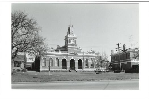 Across Learmonth street of Buninyong Town Hall, Italianate polychromatic brick building, two wings with clock tower. Butcher shop to right, andShire offices to left.