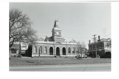 Across Learmonth street of Buninyong Town Hall, Italianate polychromatic brick building, two wings with clock tower. Butcher shop to right, andShire offices to left.