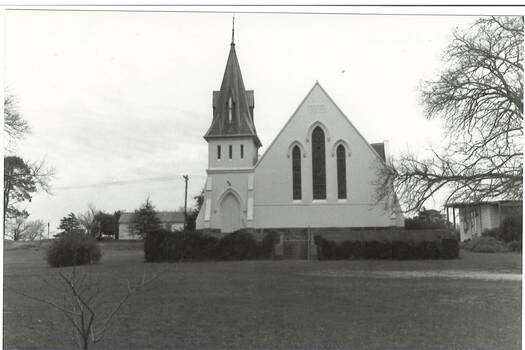 Church, white rendered, steep roof, tall steeple with ornate capping