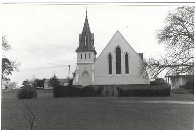 Church, white rendered, steep roof, tall steeple with ornate capping