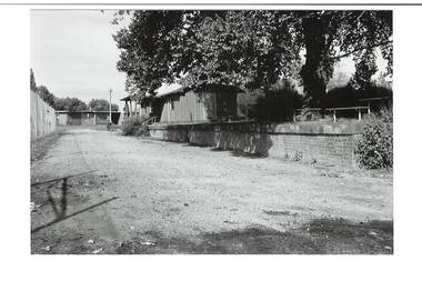 Looking towards Forest Street down former railway track, platform on right, tennis club building, elm tree, tennis court fence on left