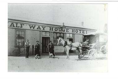 Low weatherboard building, Half Way House Hotel sign, three people, two dogs, and horse and carriage on road in front.