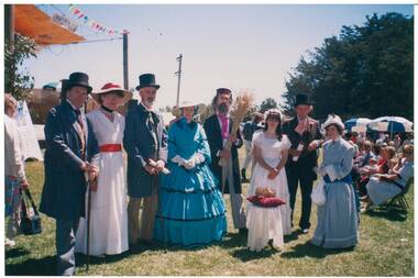 Group of people in period Victorian dress, in park.