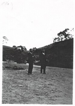 Two men stand on the river bed probably looking at the Junction Bridge, Mt Mercer. 