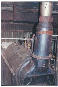 Iron boiler in corrugated iron shed, detail showing valves, rivets, chimney