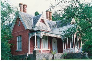 Brick house, high gables, slate roof, iron lace work, on high stone foundation