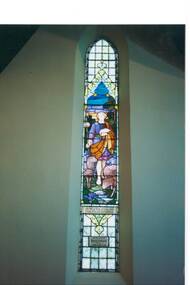 Tall, narrow gothic stained glass window, depicting Christ as Shepherd with flock.