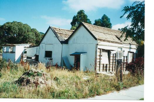Old weatherboard cottage, fibro cladding, wooden shingle roof, in process of demolition.