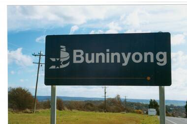 Navy Blue sign on top of hill looking down over Buninyong. Sign reads "Buninyong" with Ballarat City logo on left.