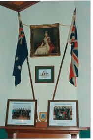 Wall and mantel piece, portrait of QEII, Australian flag and Union Jack, Victorian State Crest of Arms, group portraits of Buninyong Councillors on mantel.