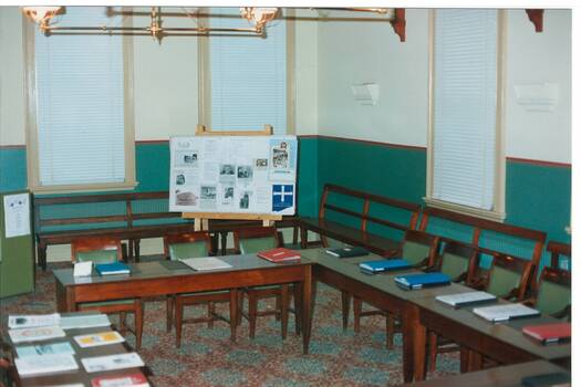 Interior Buninyong Courthouse, view to NE corner, tables with display books, display board and benches around walls.