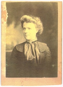 half body portrait of lady in dark Edwardian dress, with satin blouse, high neck with choker, hair piled up.