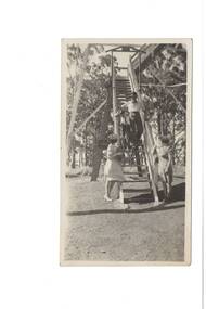 Black and White photograph of the lower stairs of the Lookout tower on Mount Buninyong. Two people are shown descending the stairs while two people wait at the foot of the stairs