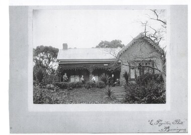 Copy of black and white photo of John Porter (seated) and four family members on the front verandah of "Fernbank" showing the front steps and part of the garden circa 1900