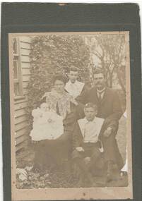 Black and white copy of an original formal photo of the McCrae family seated outside their residence in 1905.