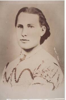 Head and shoulders portrait young lady, Victorian dress, embroidered, brooch at neck, dark hair.