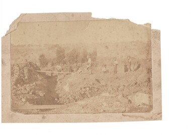 Early alluvial mining scene, 6 miners are visible carrying tools near tramway in gully