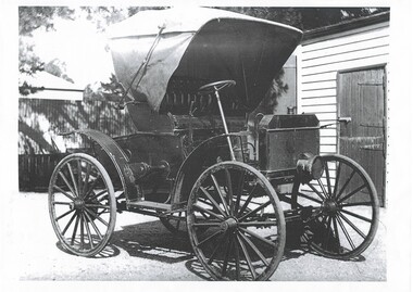 Close up view of a 1909 Schact car showing the canopy up and its carriage like construction