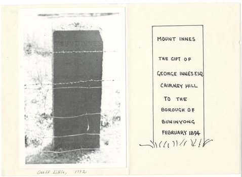 Photo of Rectangular obelisk behind barbed wire fence, grass surrounds mounted next to drawing of inscription.