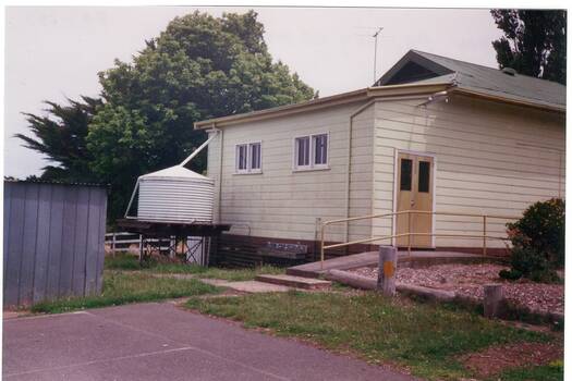 Colour photograph of the rear of the main school building of the former Yendon Primary school after its closure showing part of the old asphalt playground.