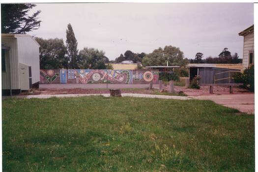 Coloured photograph of Yendon Primary School in 1994 after its closure featuring the playground and the mural on the boundary fence.