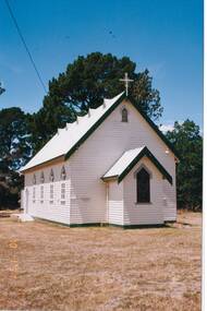 White painted weatherboard church, gabled tin roof, Gabled entrance, arched windows.